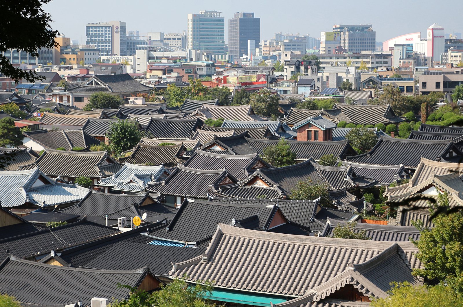 Tiled hanok rooftops of Jeonju Hanok Village with hills behind