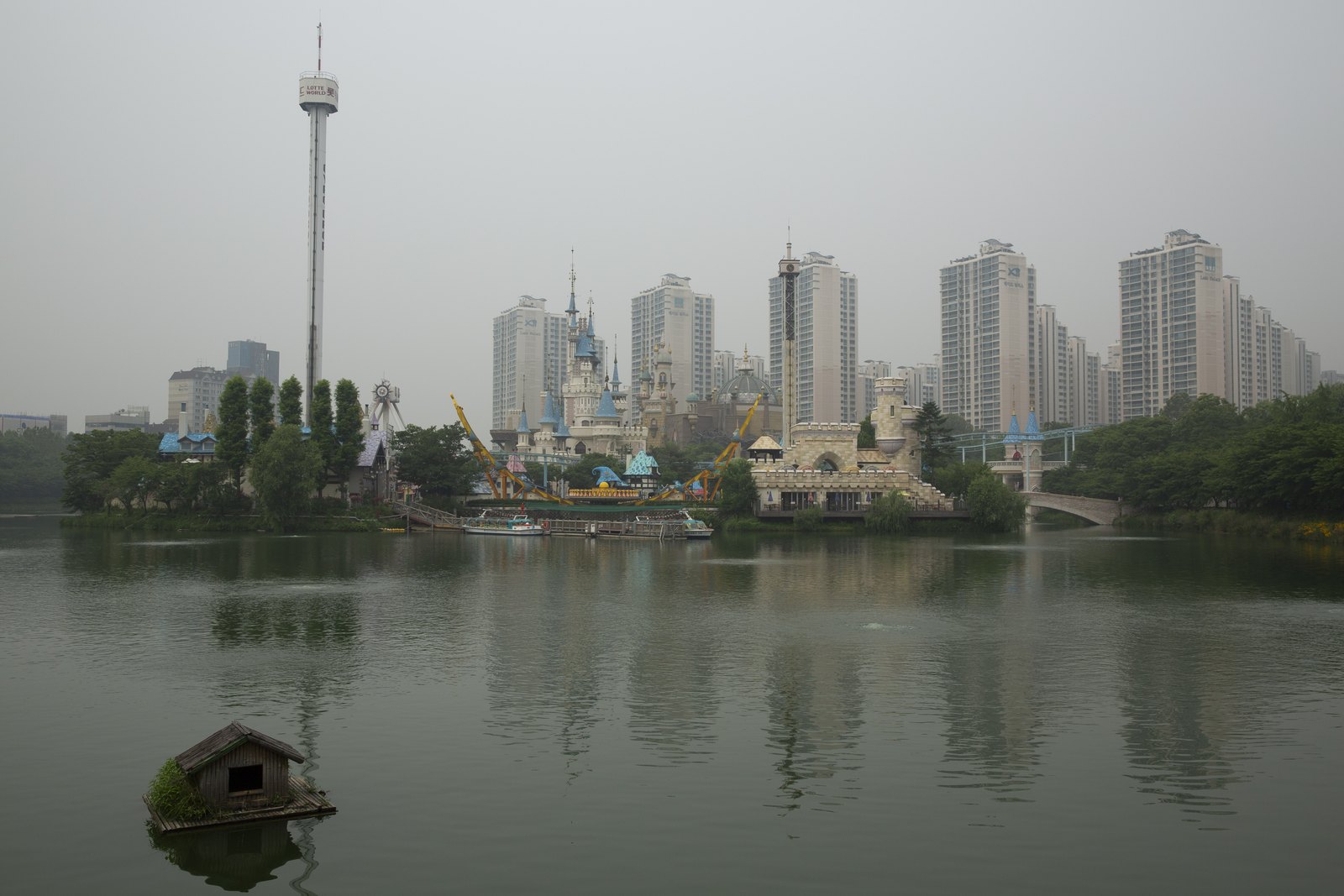 Lotte World's Magic Island castle on Seokchon Lake with Lotte World Tower behind, Jamsil, Seoul