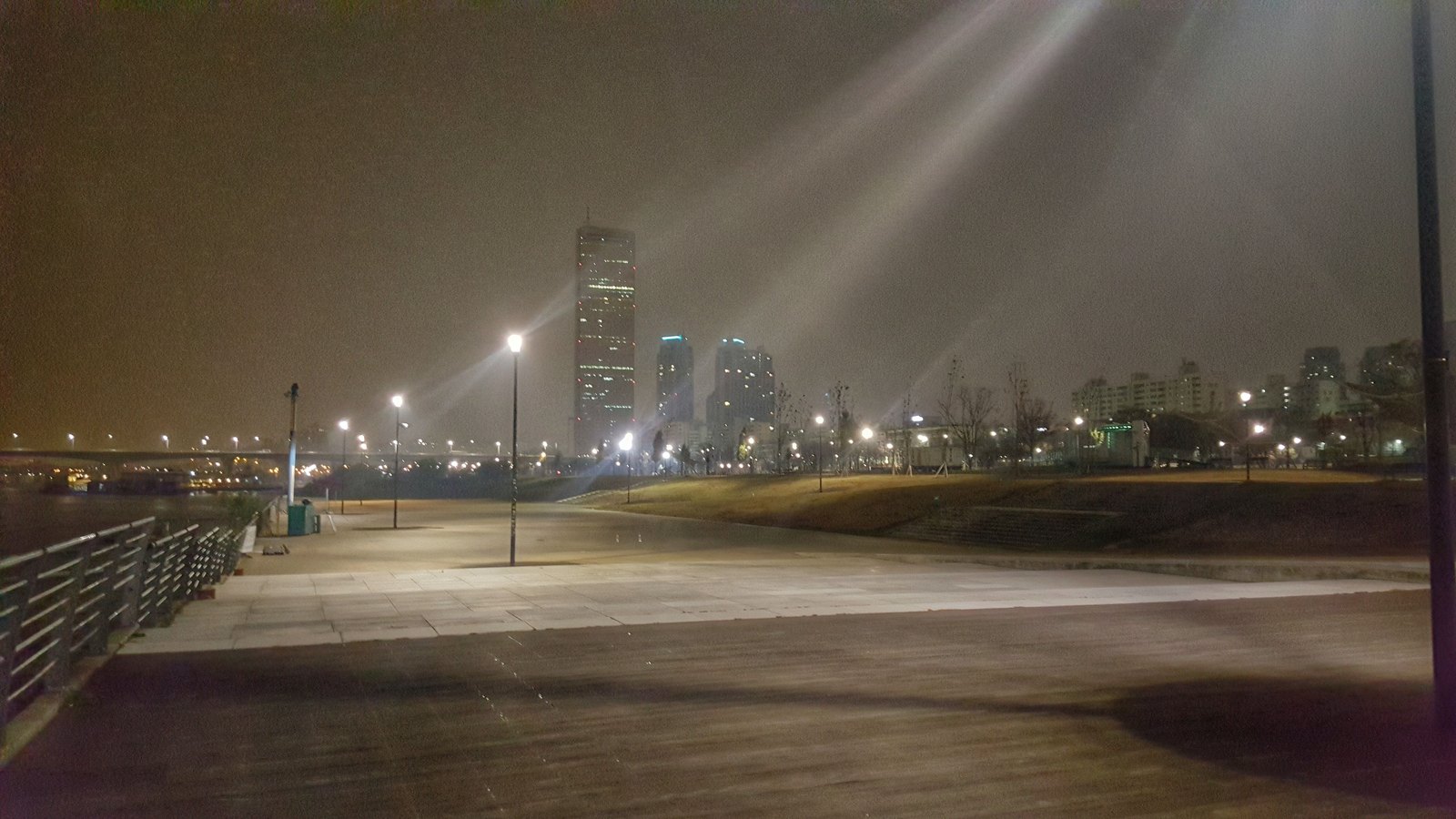 Yeouido Hangang Park at night with the golden 63 Building reflected in the Han River, Seoul